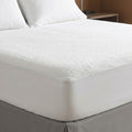 Fitted mattress protector on bed