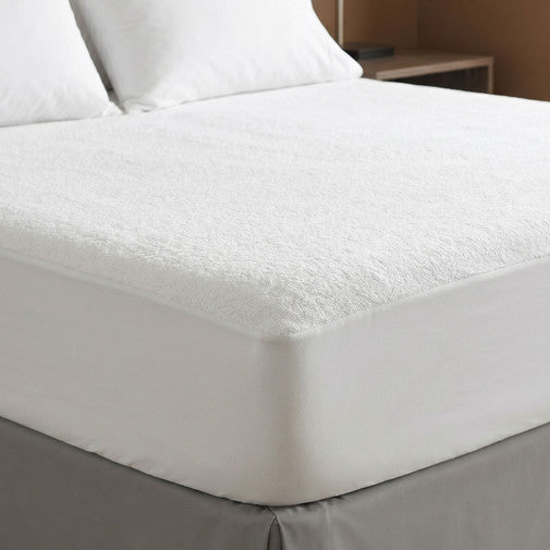 Fitted mattress protector on bed
